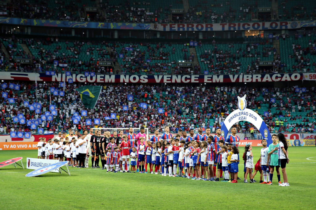Times de Bahia e Flamengo perfilados na Arena Fonte Nova em jogo do Brasileirão; torcedor-mirim recebe ingresso