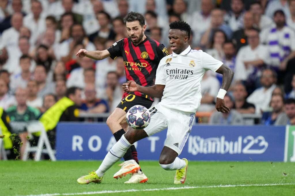 Vinícius Júnior e Bernardo Silva duelam pela bola em Real Madrid x Manchester City