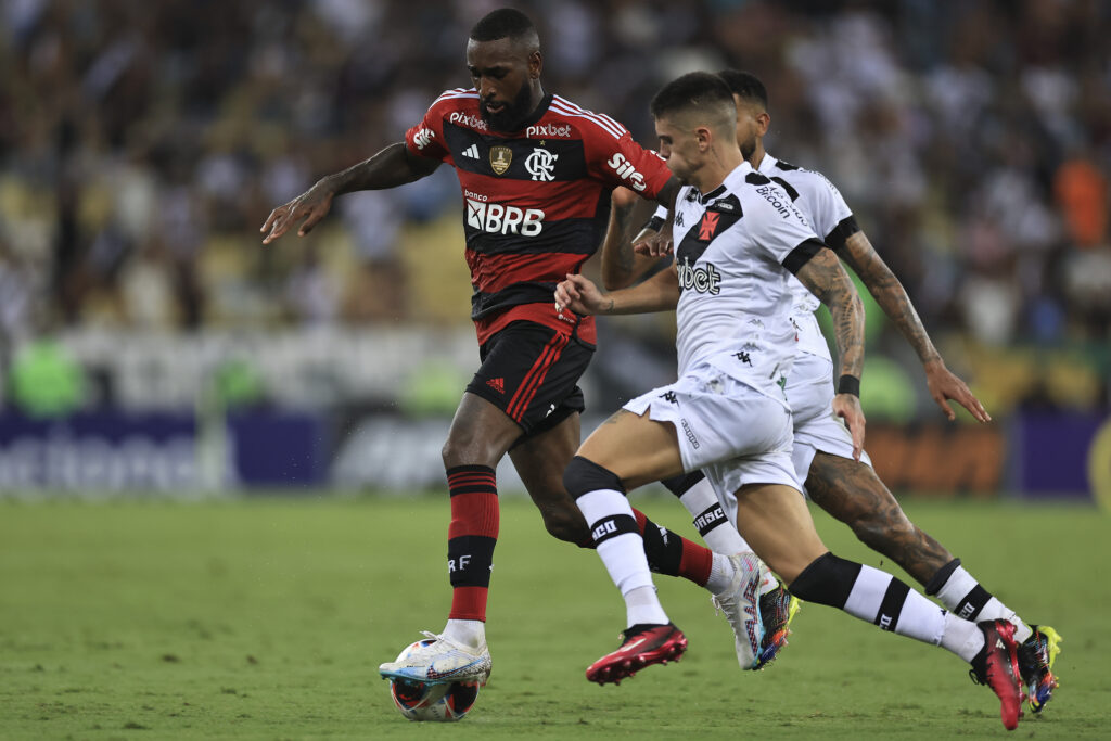 Gerson carrega a bola entre dois defensores em Flamengo x Vasco