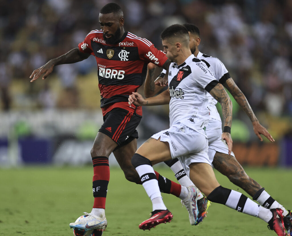 Gerson carrega a bola entre dois defensores em Flamengo x Vasco
