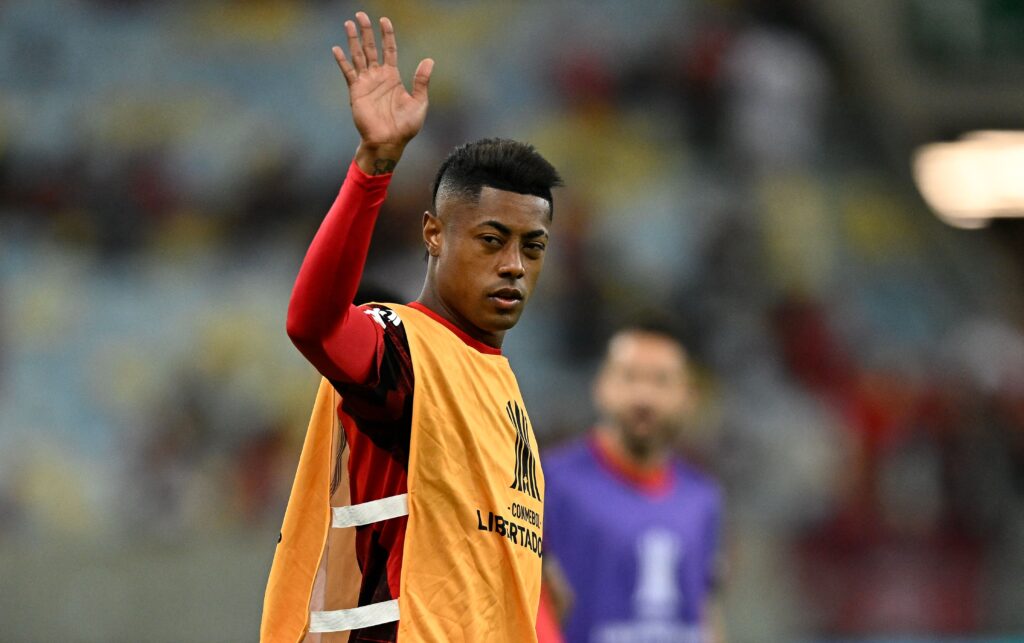 Bruno Henrique acena para câmera durante aquecimento do Flamengo; dirigente usa bordão do atleta durante reunião do conselho