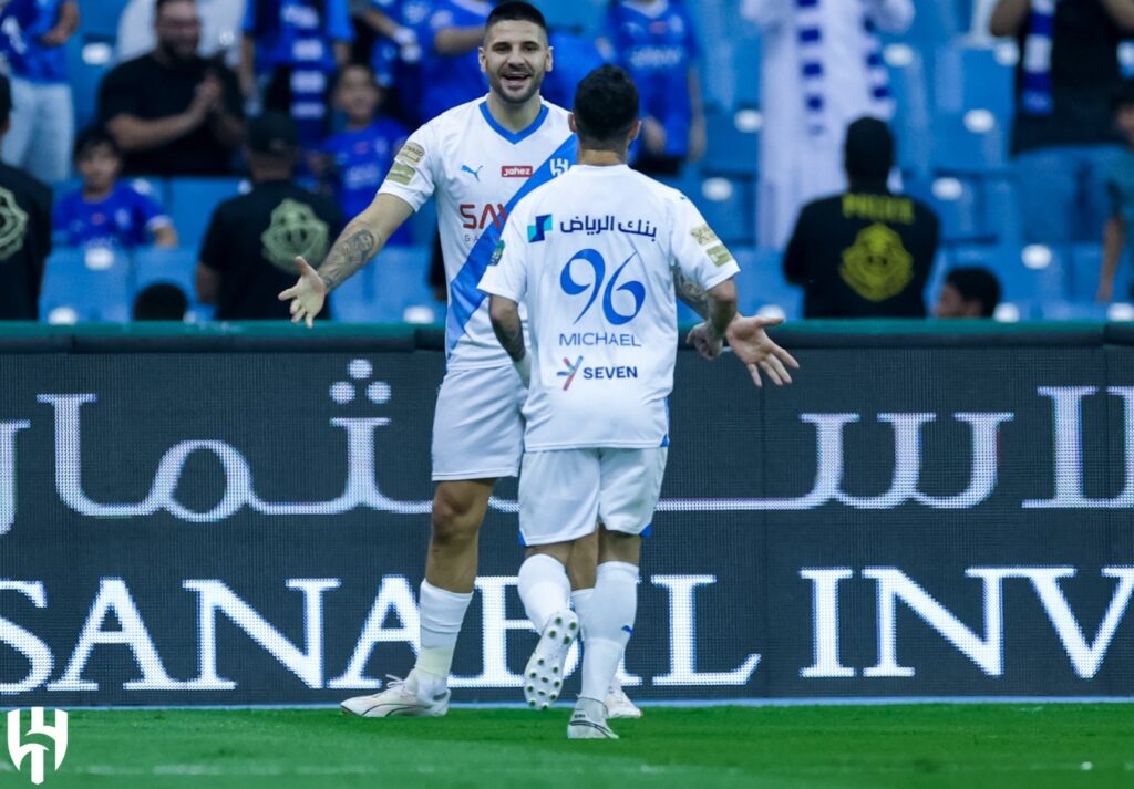 Michael e Mitrovic comemorando gol. Atacante deu assistência na vitória do Al-Hilal sobre o Al-Hazm, de outro ex-Flamengo