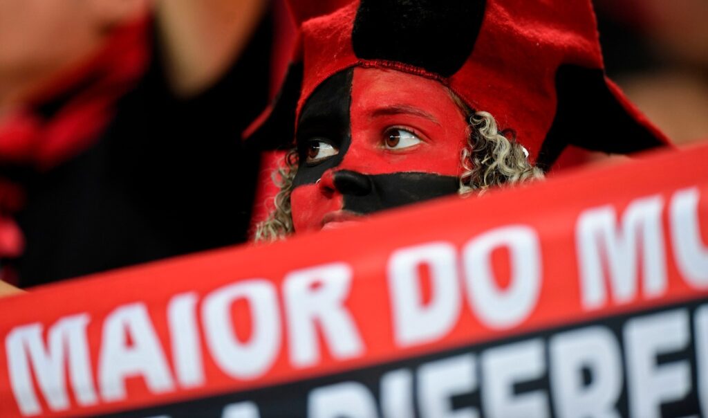 Torcedora do Flamengo ostenta faixa "Maior do Mundo" na arquibancada da Arena do Grêmio