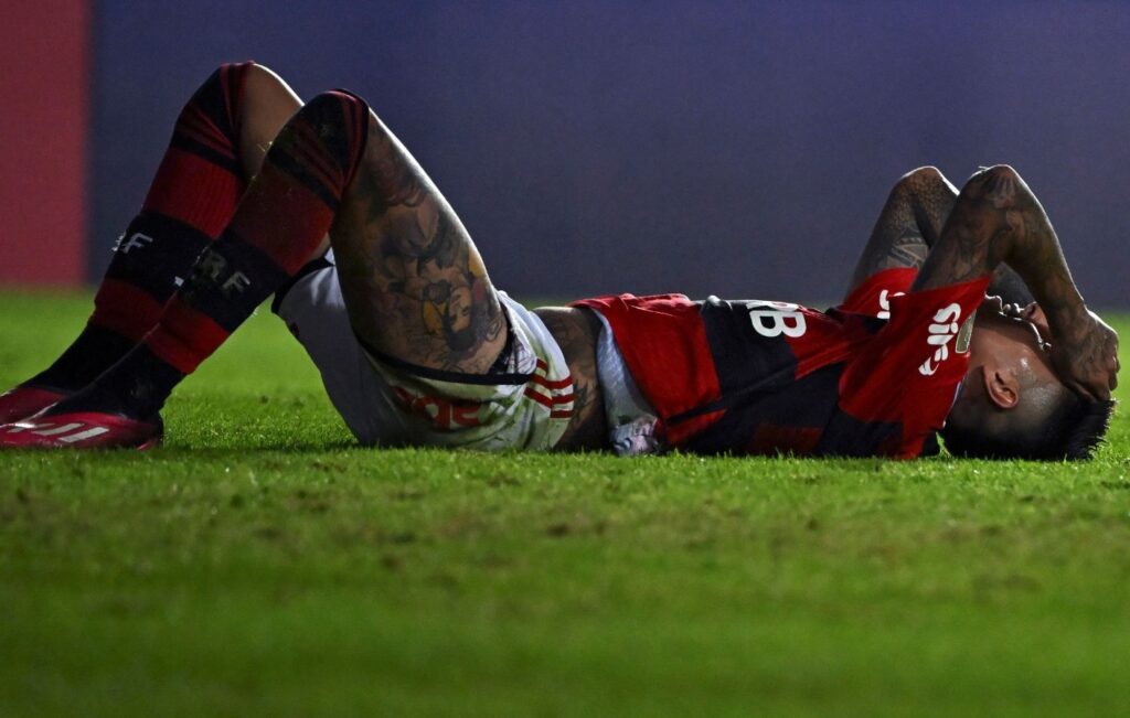 Erick Pulgar deitado em campo durante jogo do Flamengo