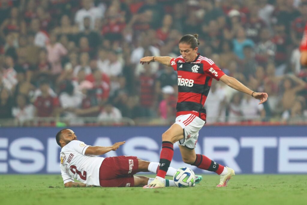 Filipe Luís, do Flamengo tenta passar por Samuel Xavier, do Fluminense. Jogador falhou no gol do Fluminense. O jogo, válido pela 33ª rodada do Brasileirão, terminou emapatado em 1 a 1.
