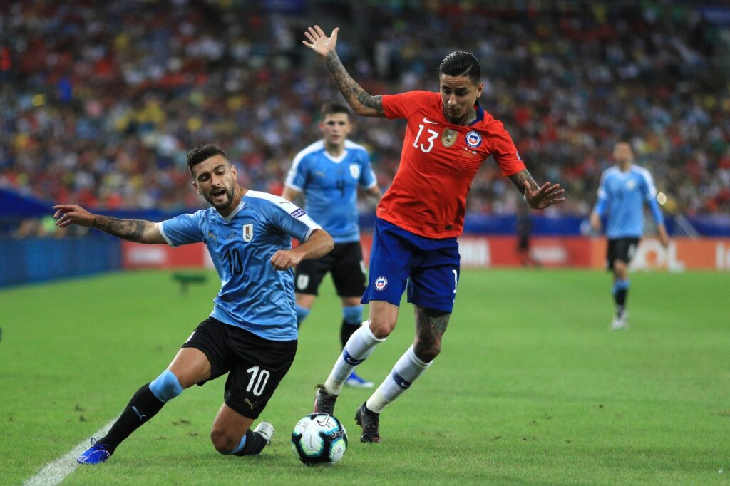 Foto que mostra dividida entre Arrascaeta e Pulgar em jogo entre Uruguai e Chile válido pela fase de grupos da Copa América de 2019