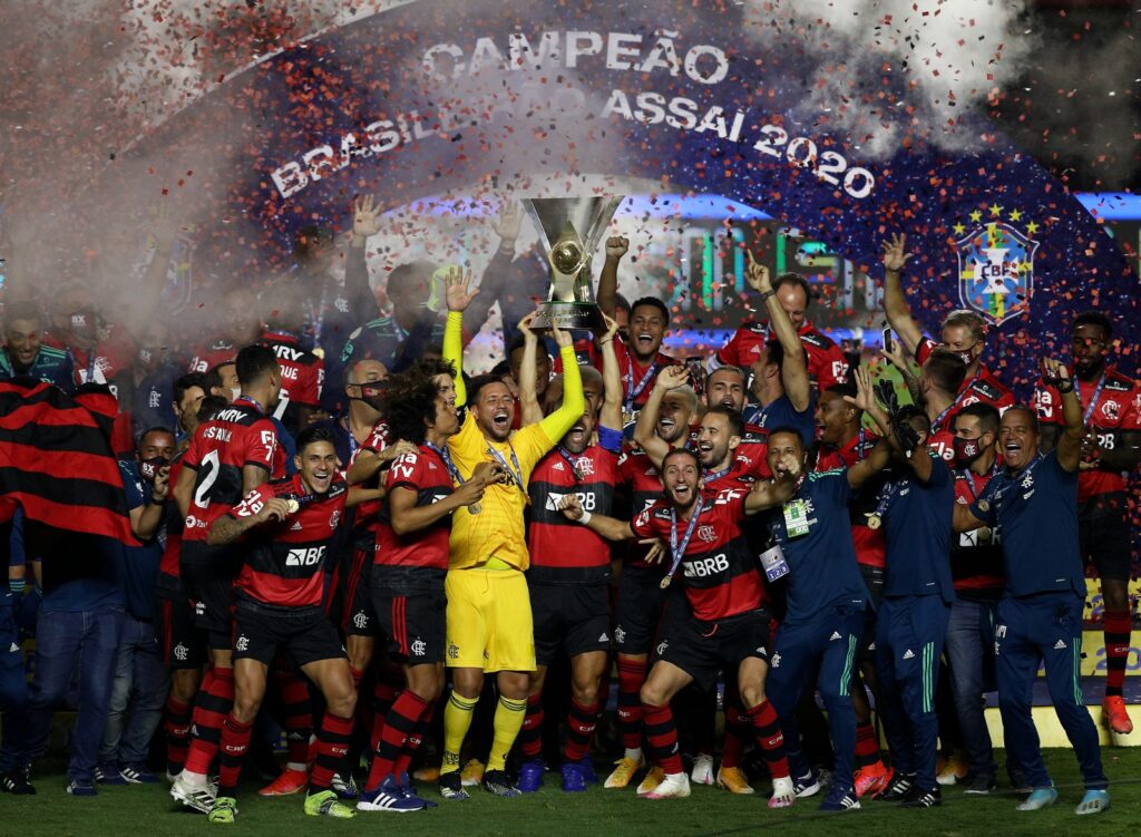 Jogadores do Flamengo erguem a taça de campeão brasileiro em 2020. Com vitória contra América-MG, Flamengo virou líder do Brasileiro pela primeira vez desde a última rodada de 2020, quando conquistou octa