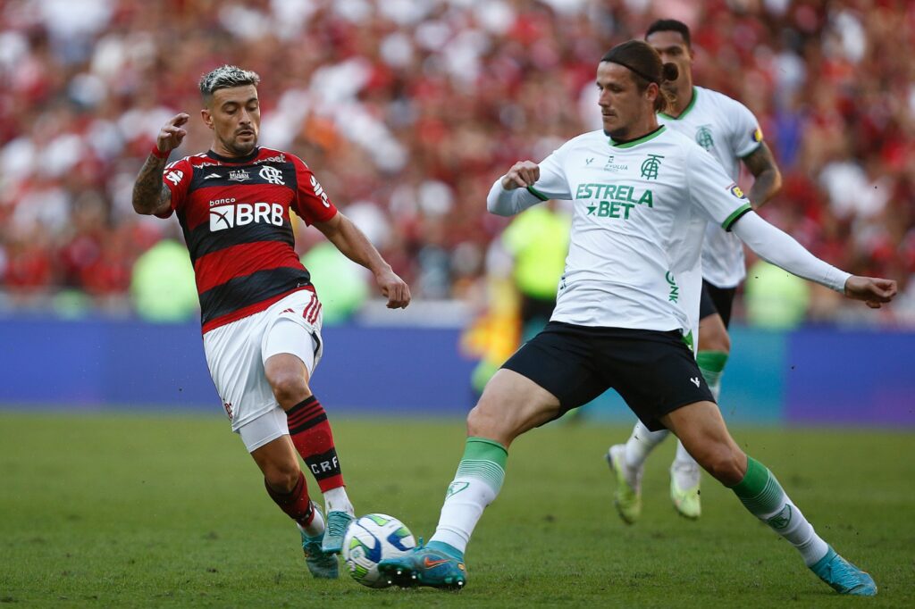 Giorgian de Arrascaeta, do Flamengo, briga pela bola com Iago Maidana, do América MG, durante a partida entre Flamengo e América MG, no Brasileirão 2023