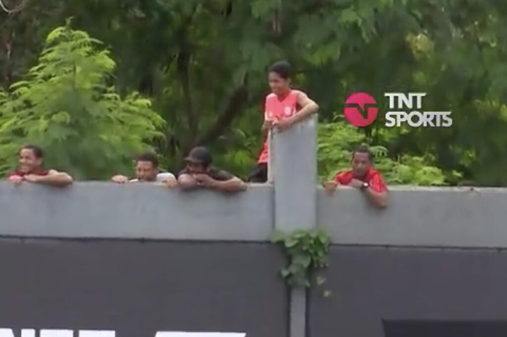 Torcedores do Flamengo sobem no muro do CT do Vasco para apoiarem os jogadores do Boca Juniors