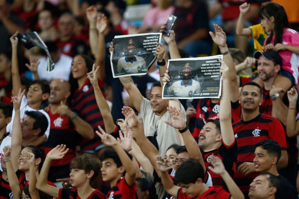 Torcedores do Flamengo seguram cartazes em apoio ao jogador Vinicius Junior, do Real Madrid, durante partida entre Flamengo e Cruzeiro, no Brasileirão