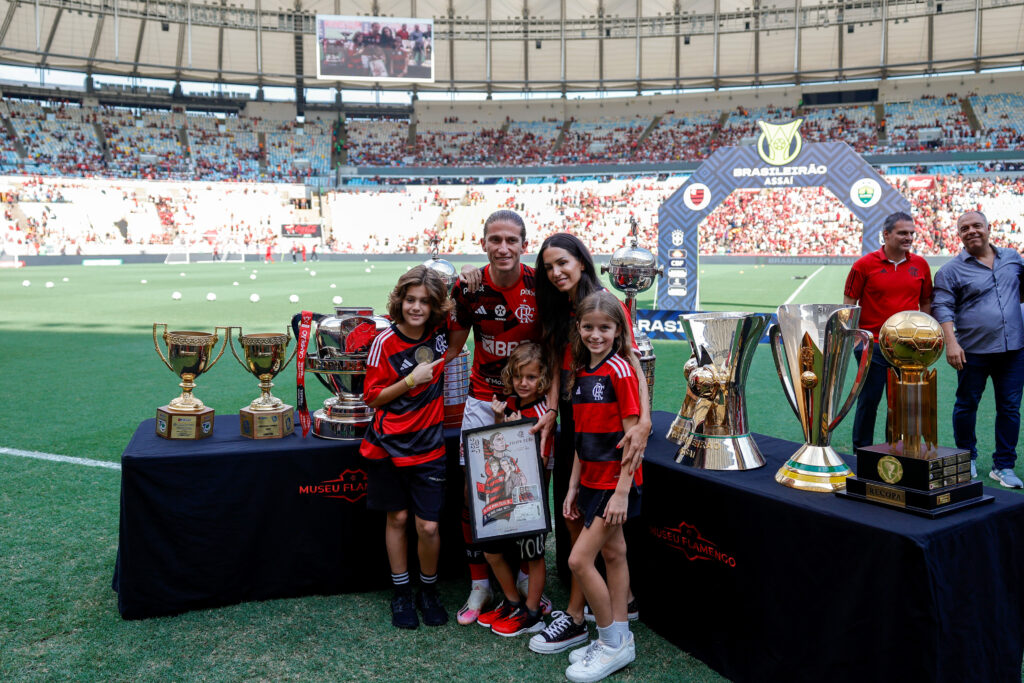 Filipe Luís com sua família, taças pelo Flamengo e placa em sua homenagem 