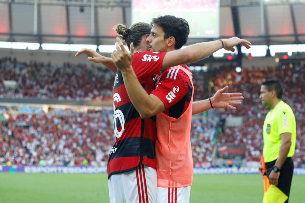 Filipe Luís e Rodrigo Caio abraçados em jogo do Flamengo contra o Cuiabá; veja as últimas notícias