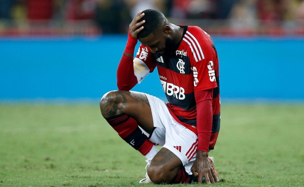 Gerson senta e leva as mãos à cabeça dentro de campo durante jogo do Flamengo