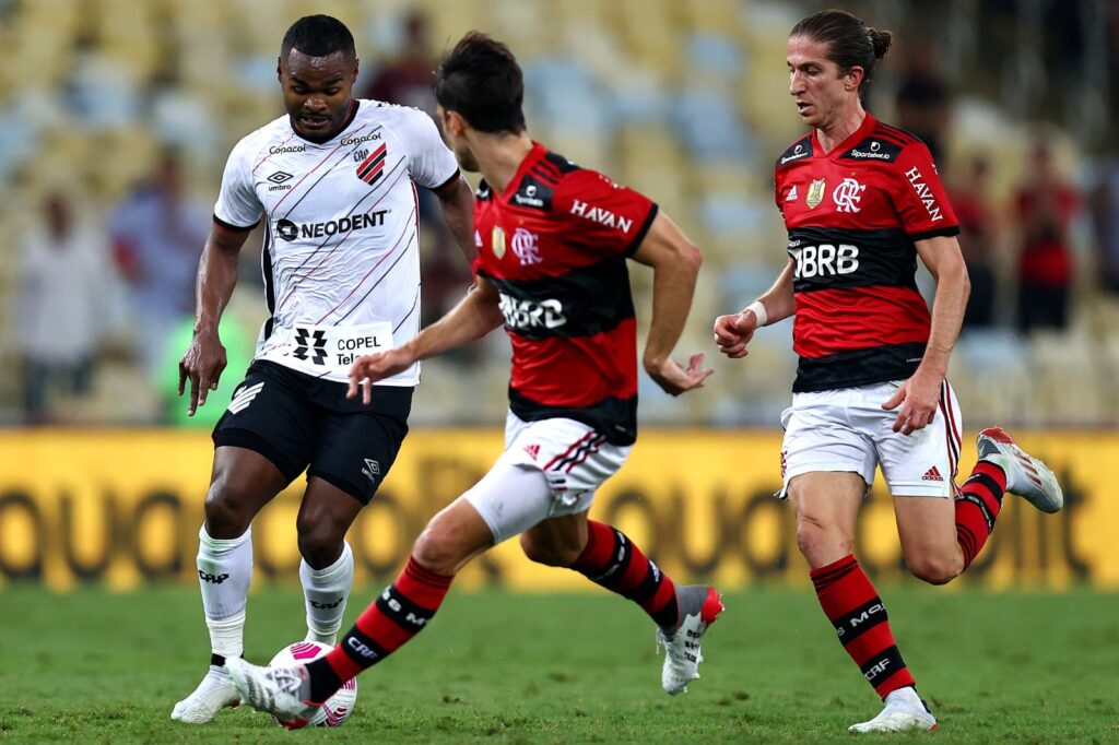 Rodrigo Caio (C) e Filipe Luis, do Flamengo, brigam pela bola com Nikao, do Athletico Paranaense, durante partida entre Flamengo e Athletico Paranaense