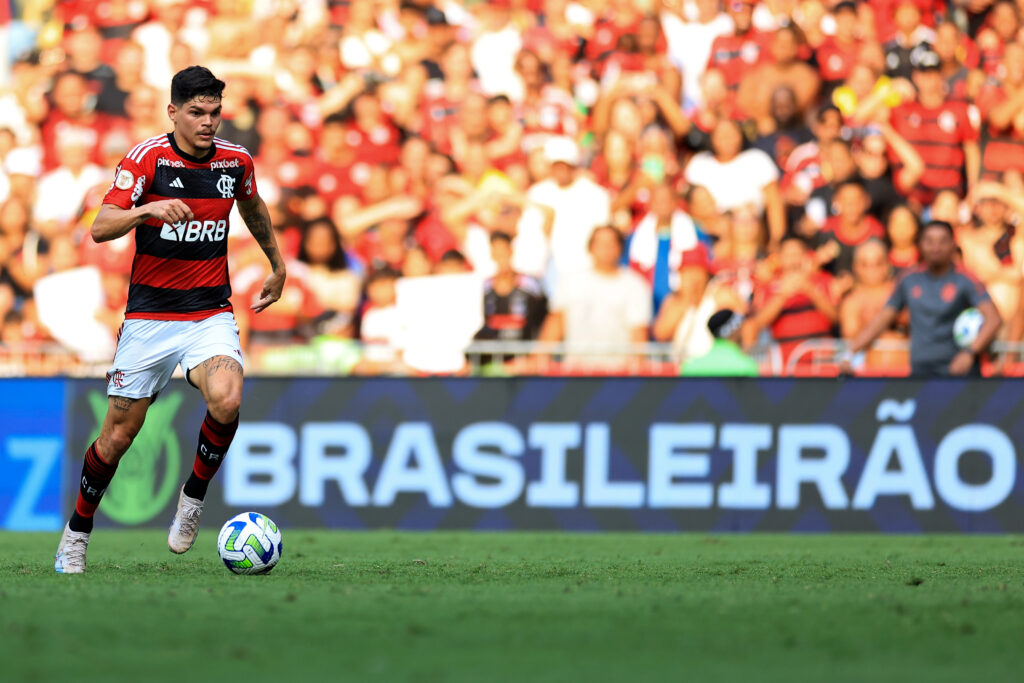 Ayrton Lucas em campo pelo Flamengo; Ao fundo, placas de publicade no jogo do Brasileirão, que o Fla deve vender os direitos comerciais para a Brax em breve