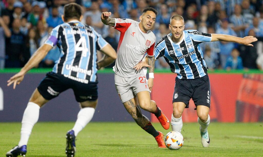 Jogadores do Grêmio em disputa de bola com Corrêa, do Estudiantes