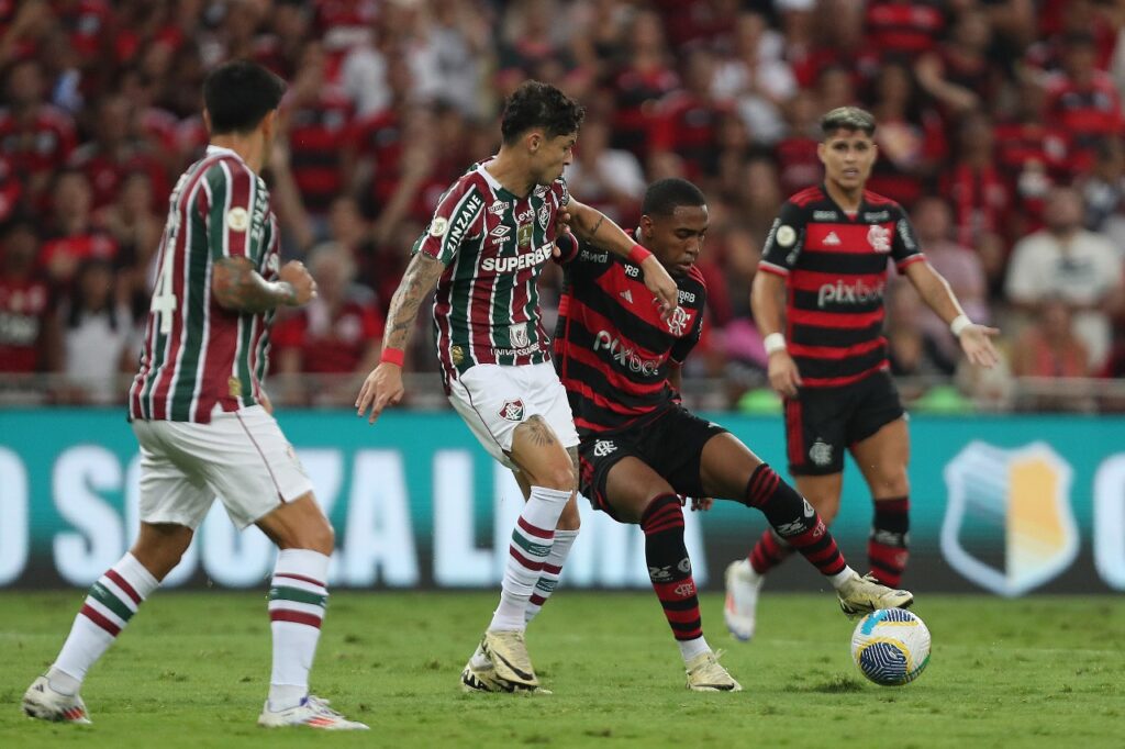Lorran carrega a bola e recebe marcação próxima de Diogo Barbosa durante Fluminense x Flamengo pelo Brasileirão 2024