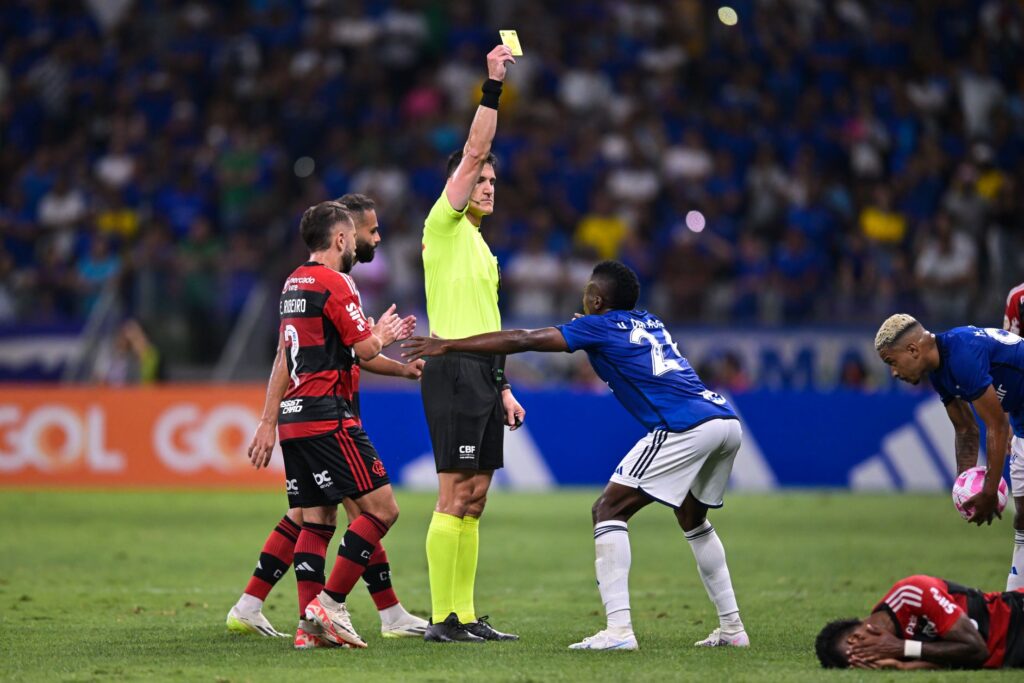 Árbitro rafael Klein mostra cartão amarelo a jogador do Cruzeiro em partida contra o Flamengo, no Brasileirão 2023