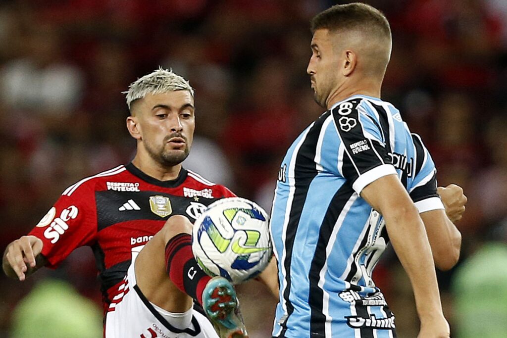 Arrascaeta, do Flamengo, disputa bola com gremista no Brasileirão 2023