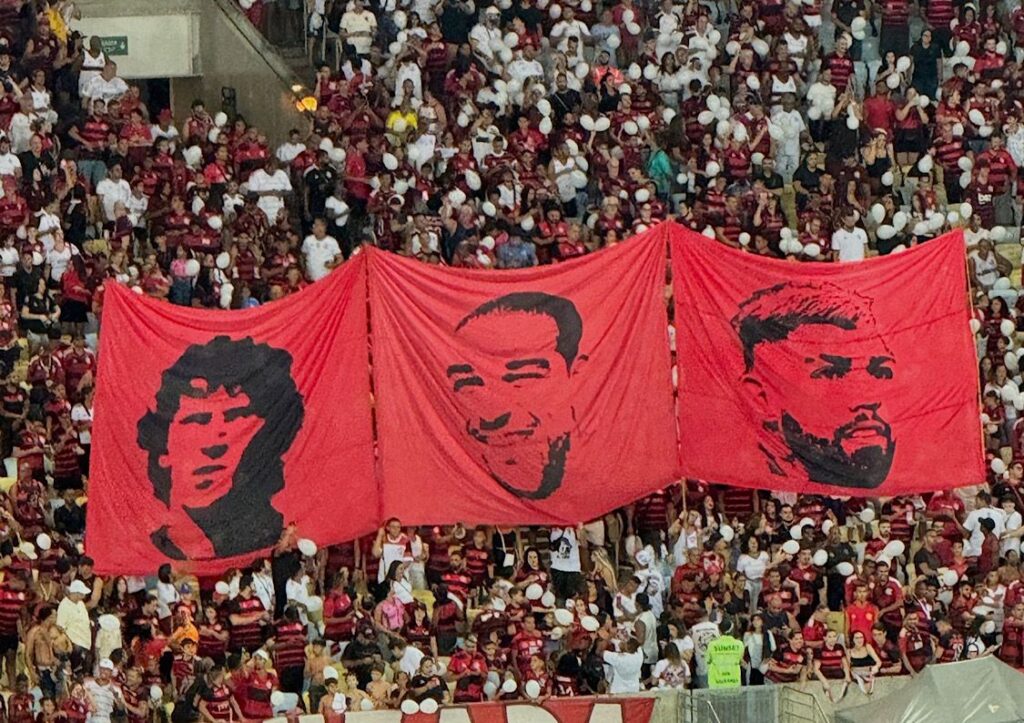 Bandeiras com os rostos de Zico, Adriano Imperador e Gabigol nas arquibancadas do Maracanã
