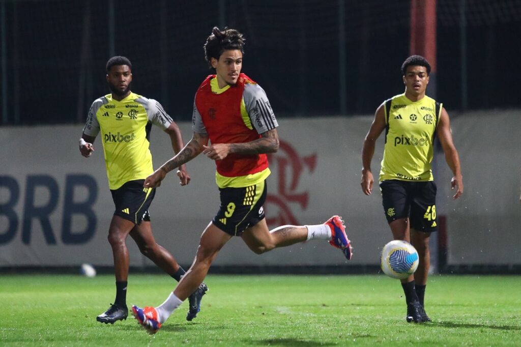 Pedro em foco no treino; ao fundo Ainoã e Igor Jesus observam. Escalação do Flamengo deve ter o atacante como titular