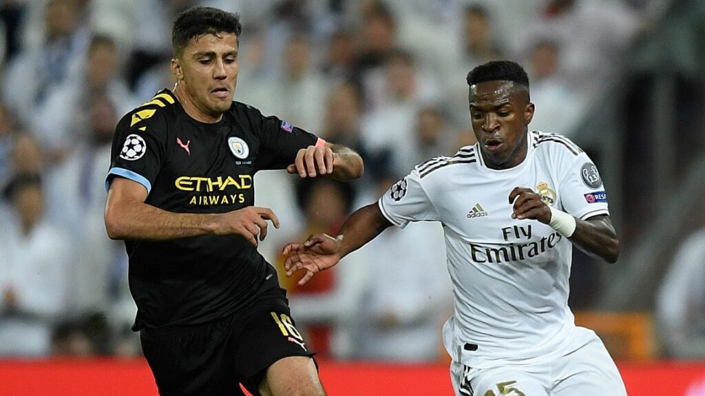 O atacante brasileiro do Real Madrid, Vinicius Junior (R), desafia o meio-campista espanhol do Manchester City, Rodri, durante a partida de ida das oitavas de final da Liga dos Campeões da UEFA entre Real Madrid CF e Manchester City, no estádio Santiago Bernabeu, em Madri, em 26 de fevereiro de 2020.