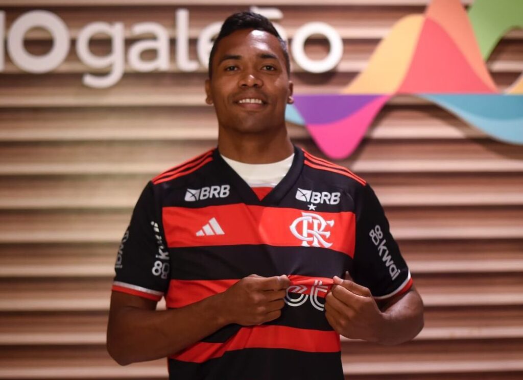 Alex Sandro com a camisa do Flamengo na chegada ao Rio de Janeiro