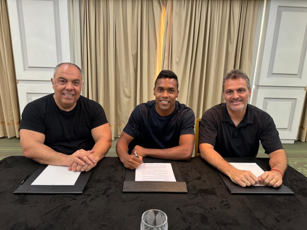 Alex Sandro de contrato assinado com o Flamengo entre Marcos Braz e Bruno Spindel, todos sorridente; time ainda poderá assinar novos reforços após fim da janela