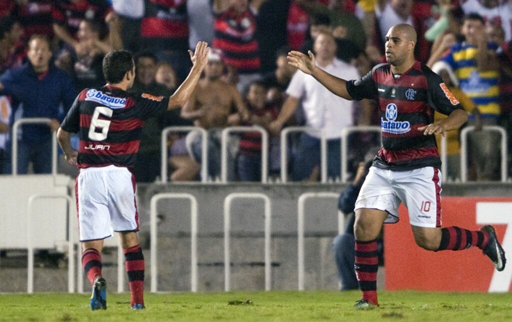 Juan, ex-lateral, e Adriano Imperador se cumprimentam durante jogo do Flamengo pela Libertadores em 2010