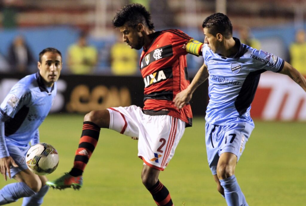 Léo Moura chuta bola em disputa com jogadores do Bolívar