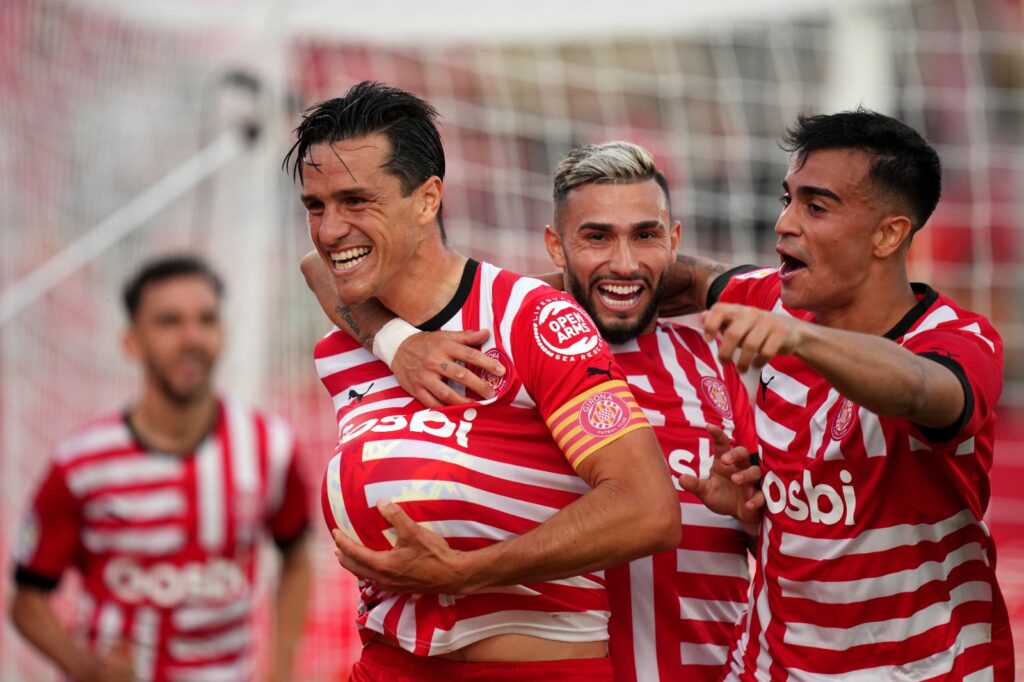 Bernardo Espinosa do Girona FC comemora com os companheiros de equipe Valentin Castellanos e Reinier após marcar o primeiro gol da equipe durante a partida da LaLiga Santander entre Girona FC e RCD Mallorca no Estádio Montilivi em 04 de maio de 2023 em Girona, Espanha.