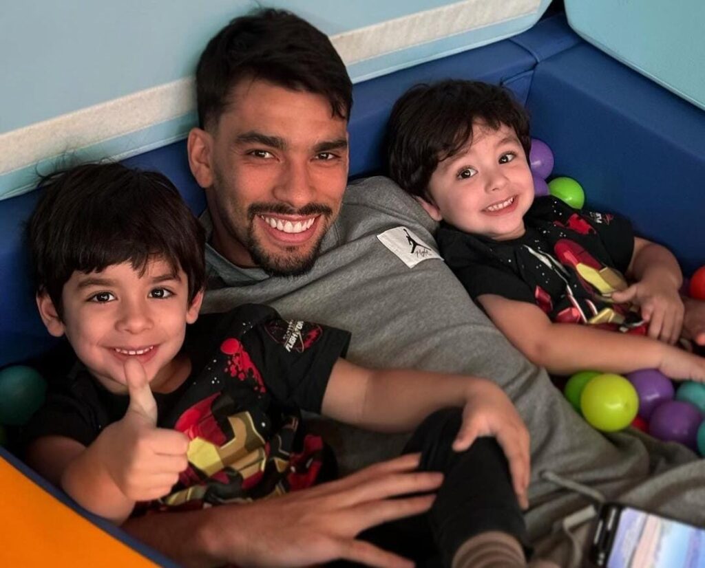 Lucas Paquetá sorri no meio de seus dois filhos, Benício e Filippo