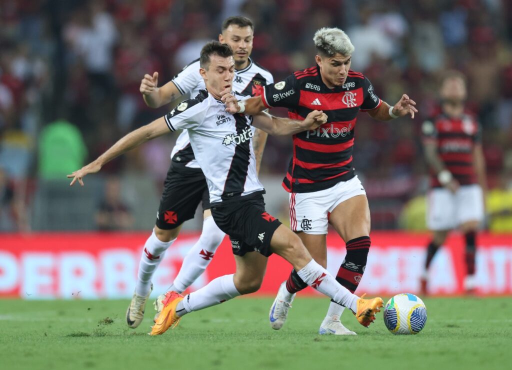 Luiz Araújo, do Flamengo, divide bola com jogador do Vasco no clássico