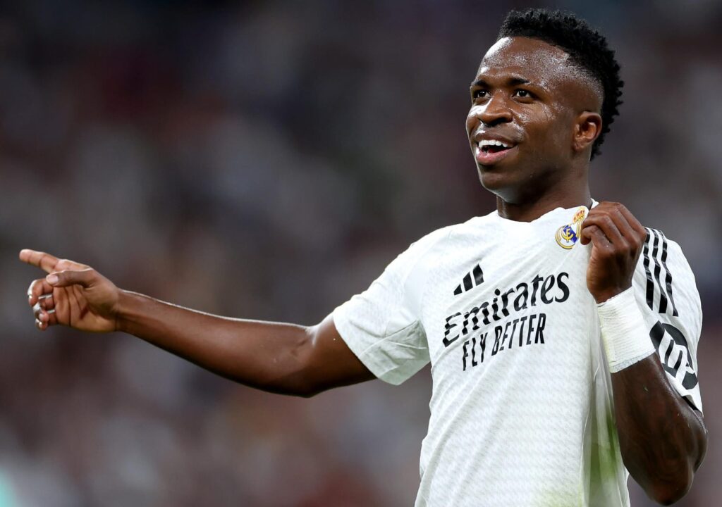 Vinícius Júnior comemora gol exibindo escudo do Real Madrid