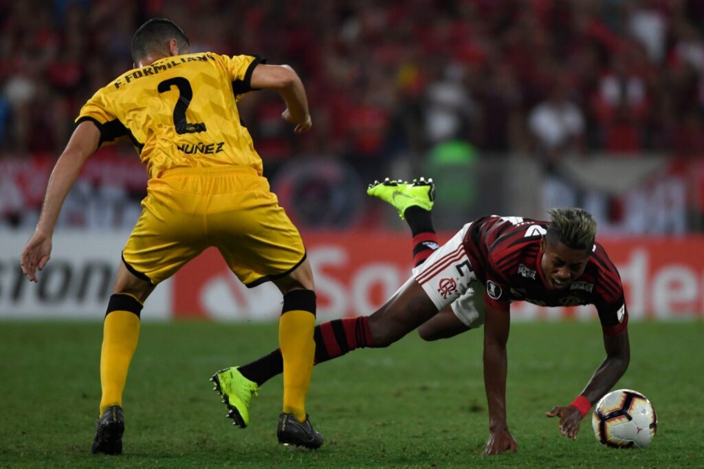 Bruno Henrique disputa a bola com o jogador uruguaio do Penarol, Fabricio Orosman Formiliano, durante partida de futebol da Copa Libertadores, no estádio do Maracanã, no Rio de Janeiro, Brasil, em 3 de abril de 2019