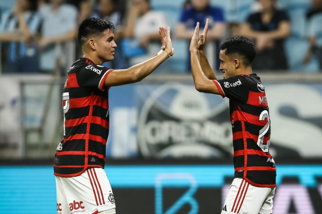 Matheus Gonçalves (D) do Flamengo comemora com o companheiro de equipe Carlos Alcaraz após marcar o primeiro gol da equipe durante a partida entre Grêmio e Flamengo como parte do Brasileirão 2024 na Arena do Grêmio em 22 de setembro de 2024 em Porto Alegre, Brasil.