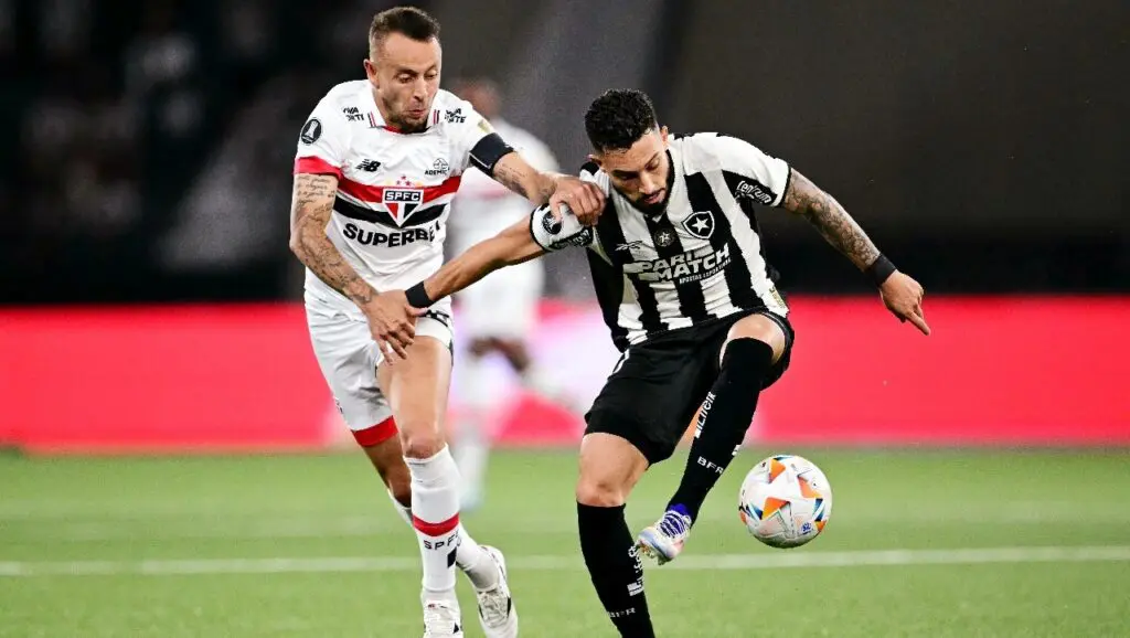 O zagueiro Rafinha (E) do São Paulo e o zagueiro Alex Telles do Botafogo disputam a bola durante a partida de ida das quartas de final da Copa Libertadores entre Botafogo e São Paulo, no estádio Olímpico Nilton Santos, no Rio de Janeiro, Brasil, em 18 de setembro de 2024.