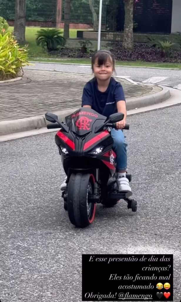 Filha de Allan com moto de brinquedo do Flamengo