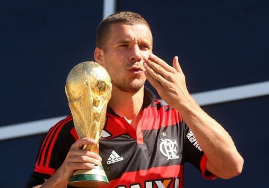 Podolski com a camisa do Flamengo após vencer a Copa do Mundo; atacante alemão se despediu do Colônia, da Alemanha