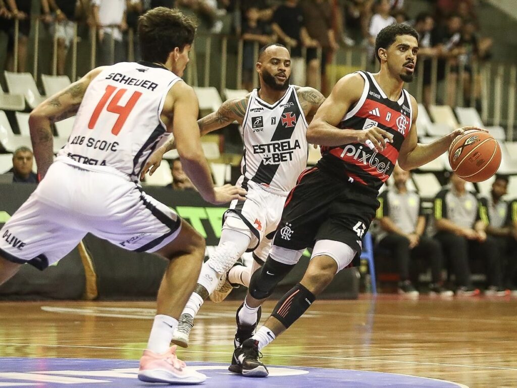 Alexey Borges com a bola sendo marcados por dois jogadores do Vasco na estreia do NBB; vitória no clássico, jogos na base, preparação para encarar o Fluminense e as últimas notícias do Flamengo