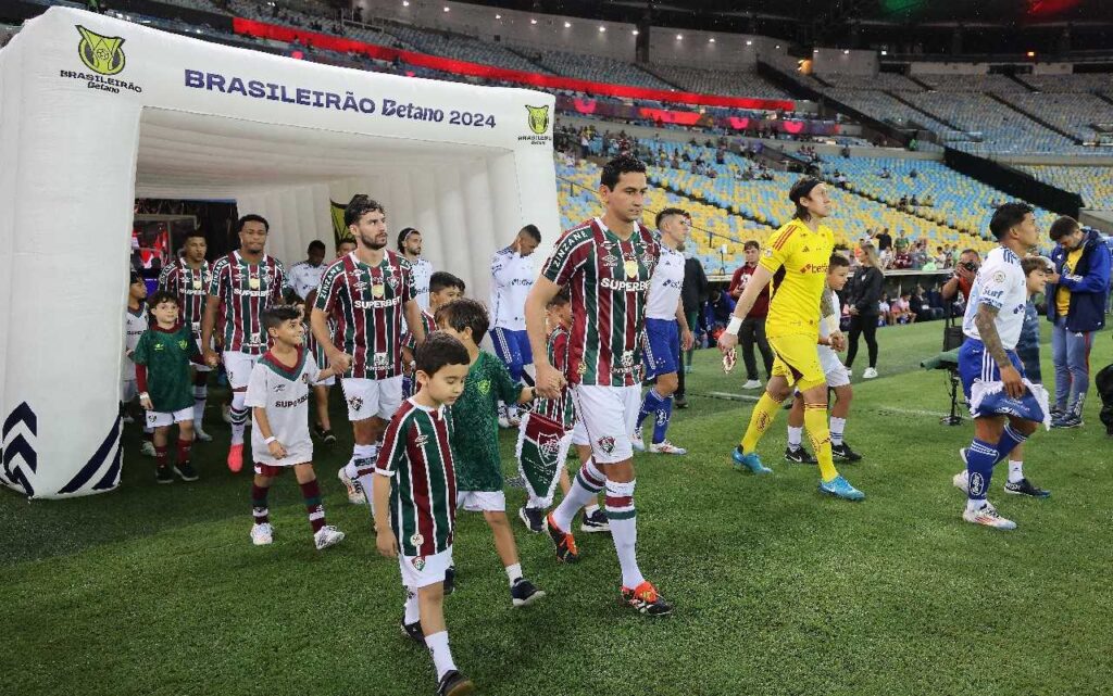 RIO DE JANEIRO, BRASIL - 3 DE OUTUBRO: Paulo Henrique Ganso (C) do Fluminense e o goleiro Cássio (2º D) do Cruzeiro entram em campo antes da partida entre Fluminense e Cruzeiro como parte do Brasileirão 2024 no Estádio do Maracanã em 3 de outubro de 2024 no Rio de Janeiro, Brasil.