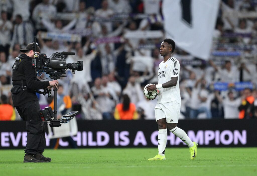 MADRI, ESPANHA - 22 DE OUTUBRO: Vinicius Junior, do Real Madrid, pega a bola da partida no final do jogo, tendo marcado um hat-trick após a vitória do time na partida da fase MD3 da Liga dos Campeões da UEFA 2024/25 entre o Real Madrid C.F. e o Borussia Dortmund no Estádio Santiago Bernabeu em 22 de outubro de 2024 em Madri, Espanha.