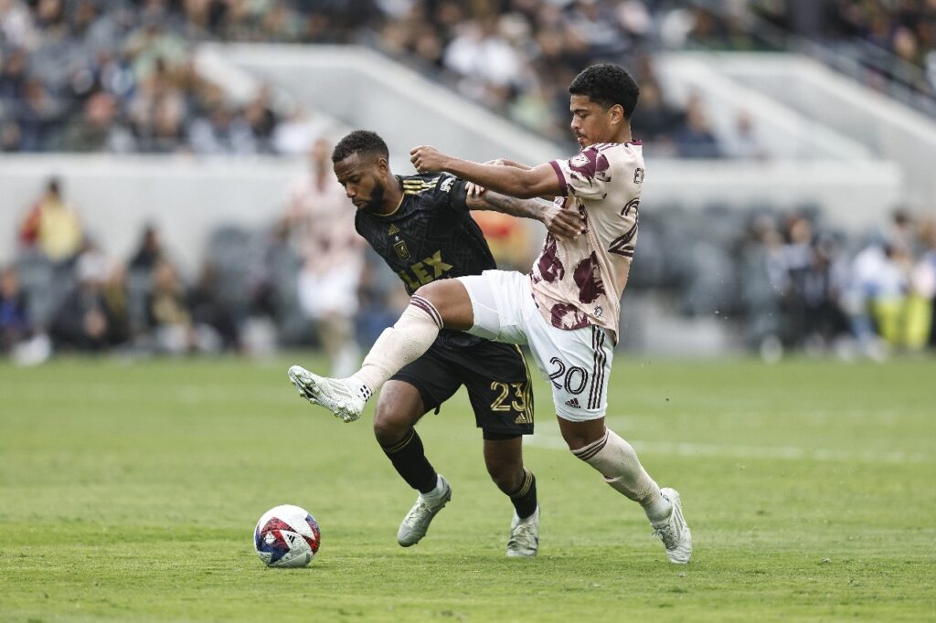 LOS ANGELES, CALIFÓRNIA - 04 DE MARÇO: Kellyn Acosta #23 do Los Angeles FC e Evander da Silva Ferreira #20 do Portland Timbers disputam a bola durante uma partida entre o Portland Timbers e o Los Angeles Football Club no BMO Stadium em 04 de março de 2023 em Los Angeles, Califórnia.